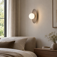 Applique murale disque allumée au-dessus d'une tête de lit dans une chambre lumineuse
