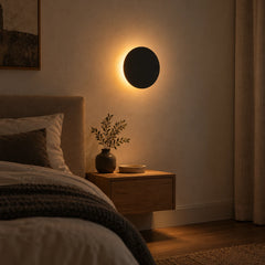 Halo de lumière indirecte autour du disque noir, chambre le soir près du lit
