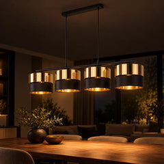 Lustre AURIA allumé le soir au-dessus d’une table en bois, lumière dorée