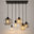 Lustre industriel 6 lumières Orive, globes de verre et platine noire sur fond neutre