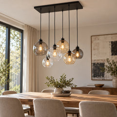 Lustre industriel Orive allumé au-dessus d’une table de salle à manger en journée