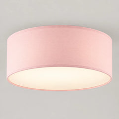 Plafonnier tambour en tissu rose allumé, diffuseur blanc, vu de trois quarts sur fond neutre