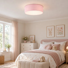 Plafonnier tambour en tissu rose au plafond d'une chambre d'enfant lumineuse en journée