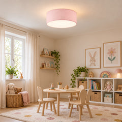 Plafonnier tambour en tissu rose allumé au-dessus d'une table de jeux pour enfants