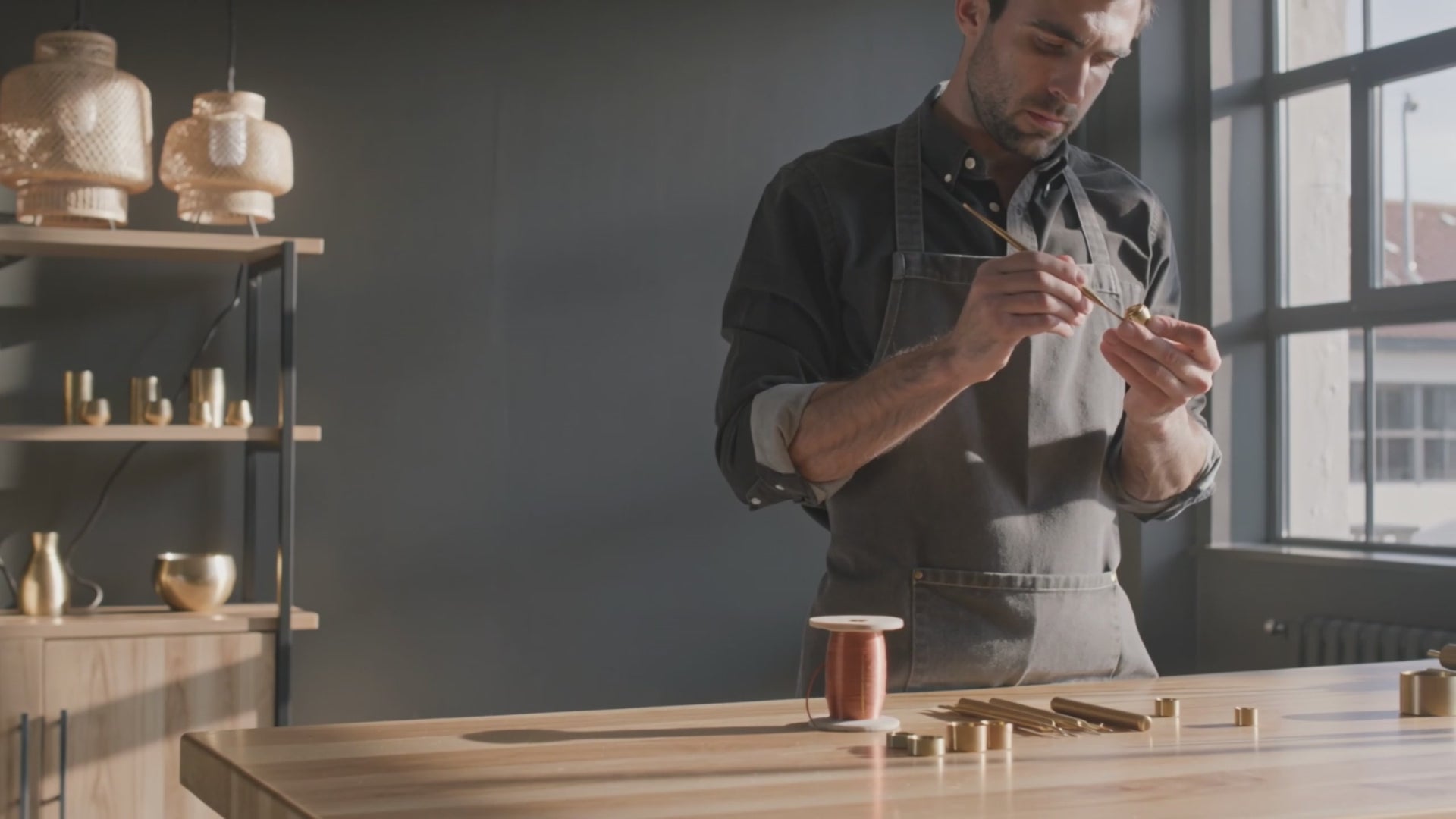 Artisan français façonnant un lustre design en laiton brossé — pièces sculpturales pour intérieurs de caractère, L'Atelier du Lustre Paris